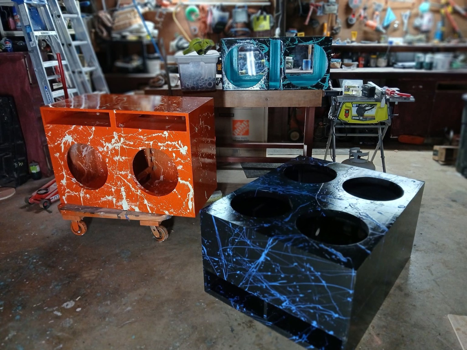 Orange, turquoise and blue splatter enclosures together in the workshop